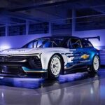 The 2025 Chevrolet Blazer EV.R NASCAR Concept car angled for a dynamic side view, showcasing its stock car modifications and racing livery.