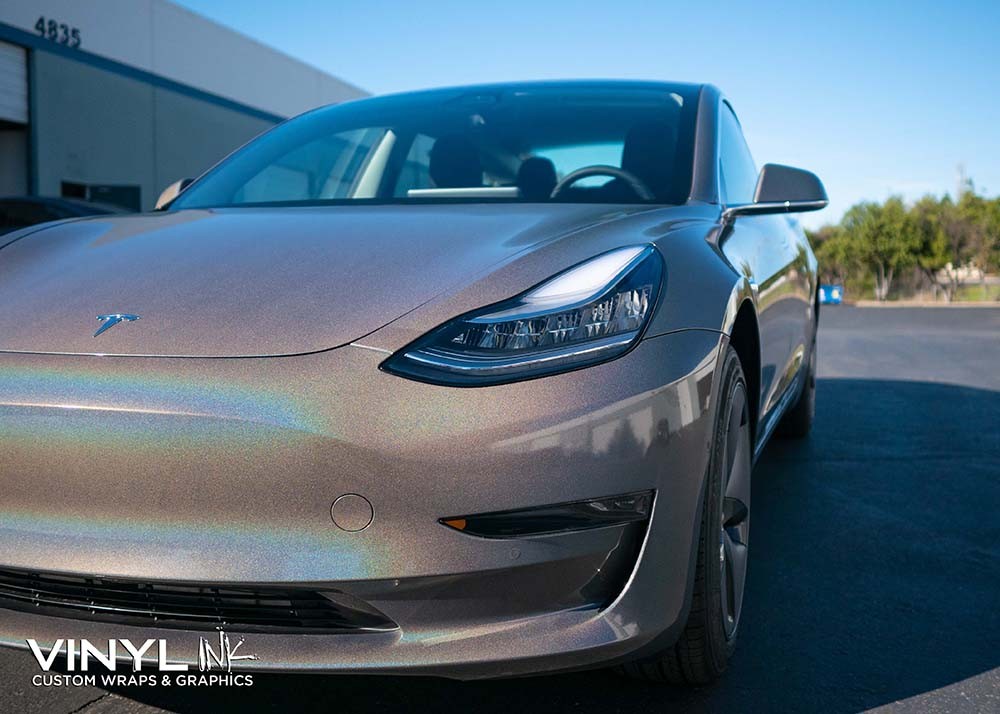 Tesla Model 3 showcasing a vibrant color shift car wrap, a cost-effective alternative to custom paint jobs.