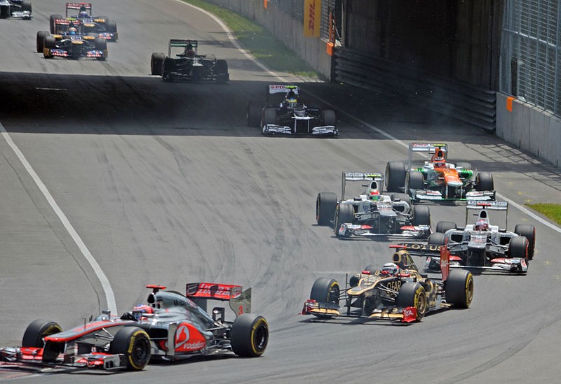 Formula 1 cars racing at the 2012 Canadian Grand Prix, featuring Jenson Button, Kimi Räikkönen, and Sergio Pérez among other drivers, highlighting the excitement of Formula 1 racing events.