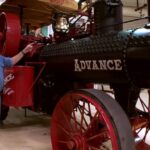 Jay Leno in his garage surrounded by classic cars