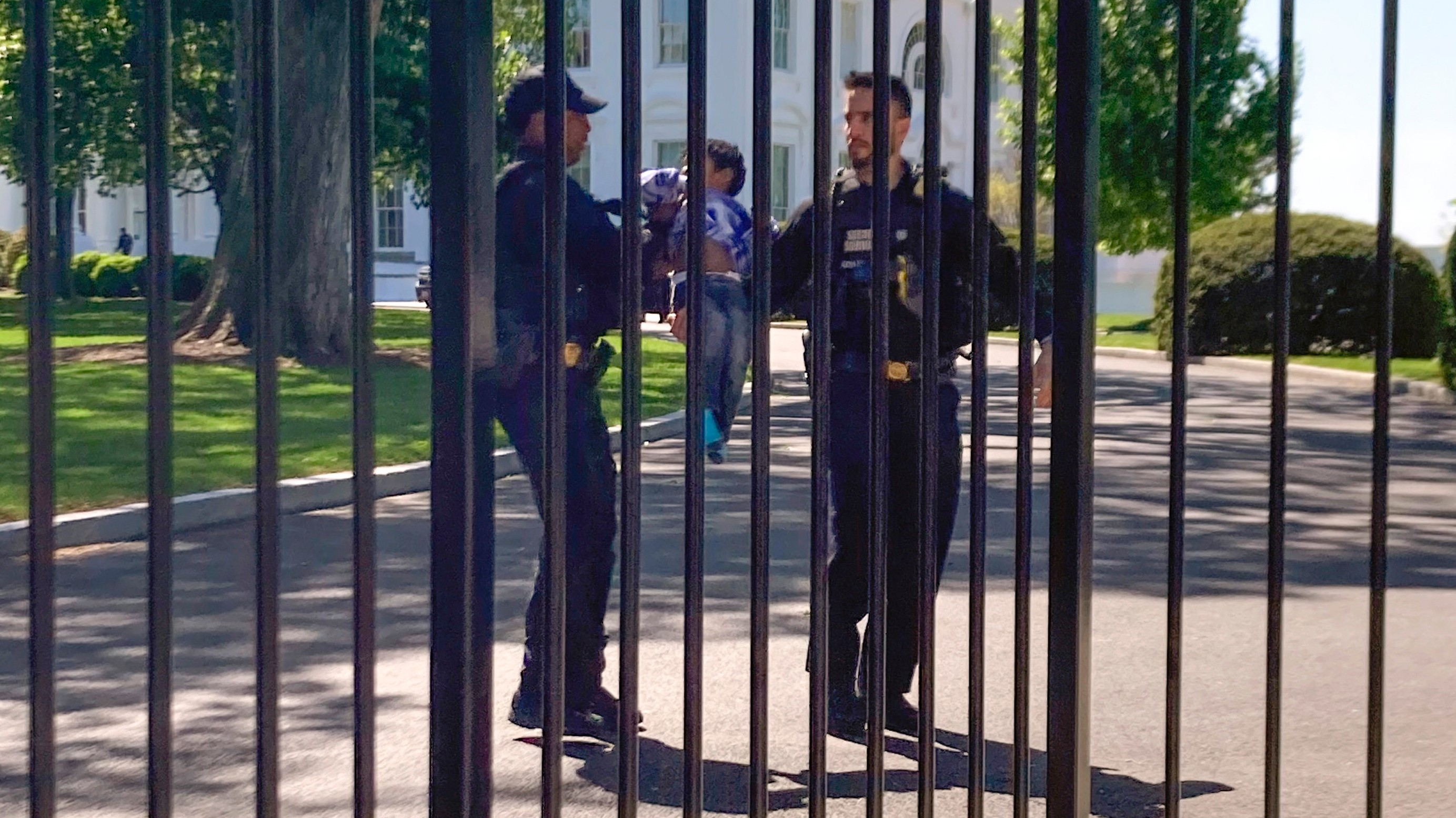 White House security fence with US Secret Service agents patrolling, illustrating general White House security measures, not directly related to the car crash incident.