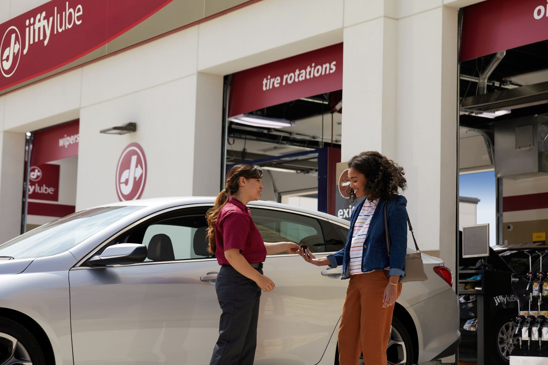 Woman talking with a Jiffy Lube technician about her car diagnostic test