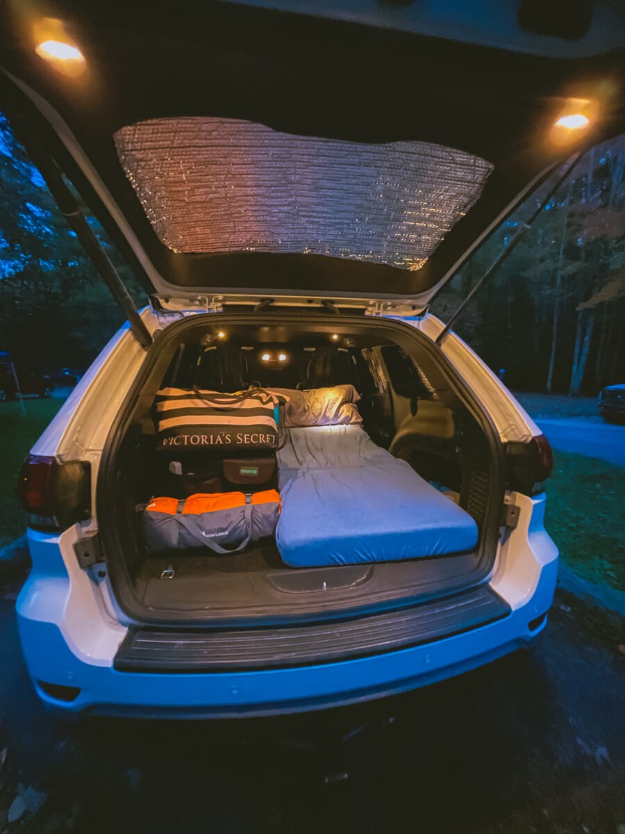 Car camping setup in a Jeep Grand Cherokee