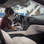 A professional detailer cleaning the inside of a car