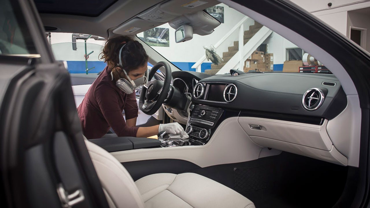 A professional detailer cleaning the inside of a car