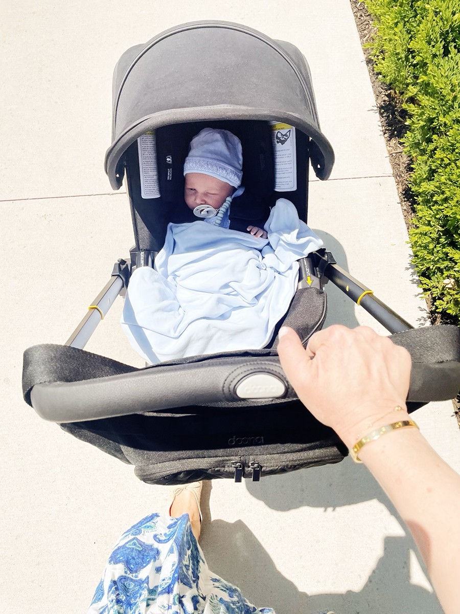 Doona car seat and stroller in stroller mode on a light wooden floor