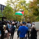 Protesters wave a Palestinian flag outside Day Hall.