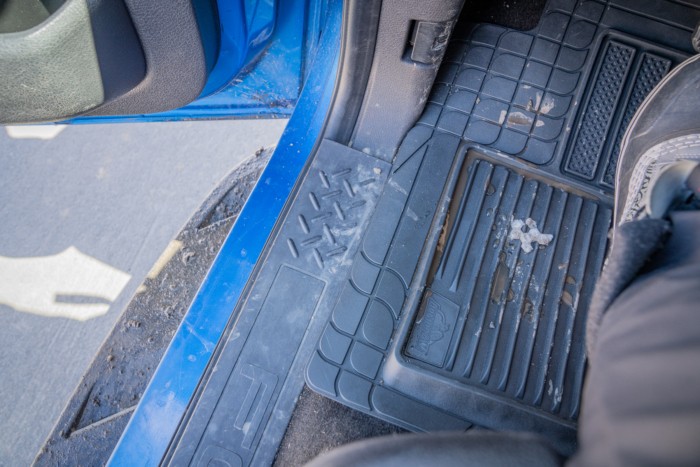 Deep grooves in a car floor mat designed to trap muck and debris