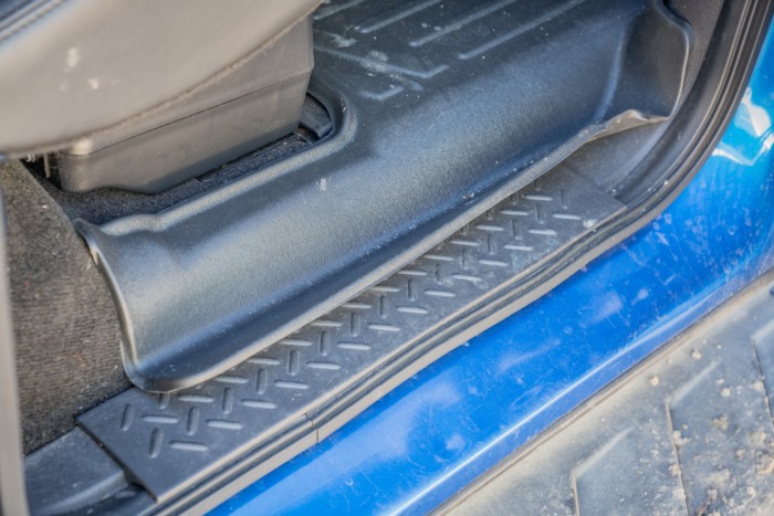 Groove along the edge of a car floor mat designed for side footwell protection