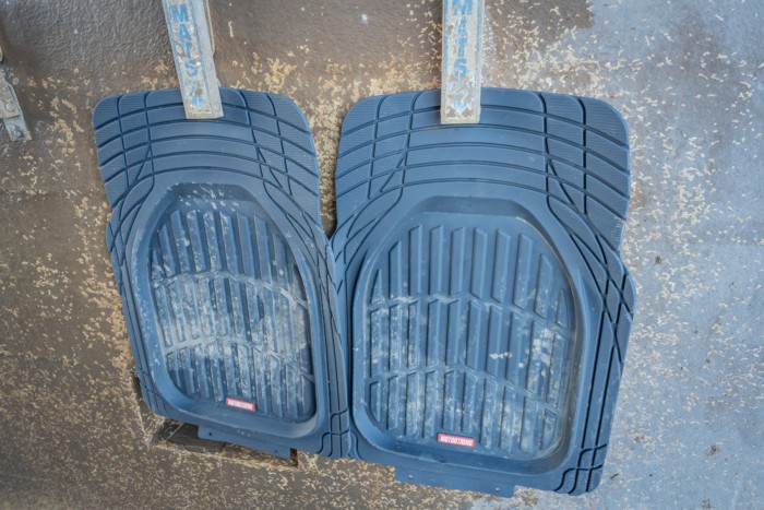 Malleable car floor mats hanging at a car wash for easy cleaning