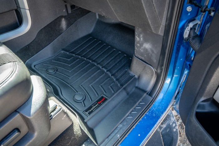 Close-up of a WeatherTech car floor mat edge, showcasing rigid plastic construction