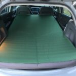 Chevrolet Bolt interior with Exped MegaMat Duo mattress fully extended showing trunk space and vehicle hood