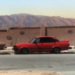 Isuzu I-Mark sedan with custom red paint job and aftermarket wing