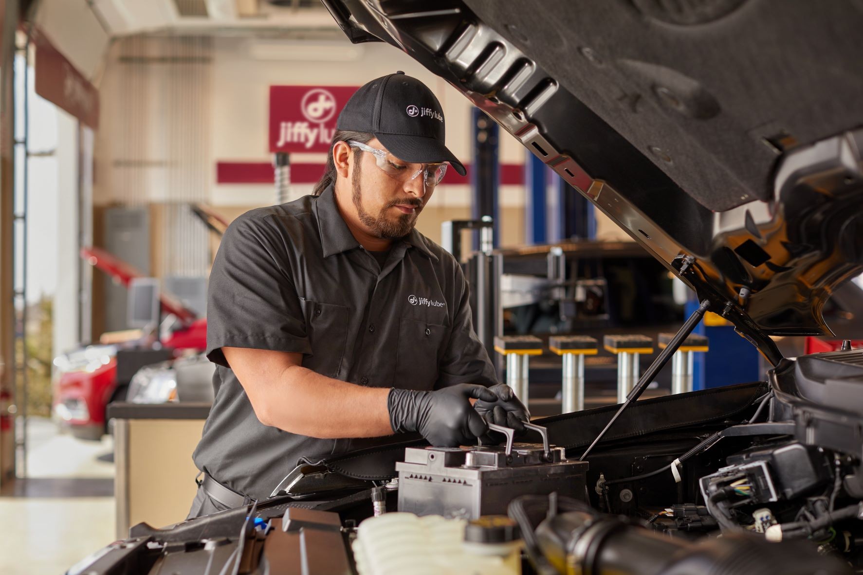 A JiffyLube Technician changes out a customer car battery