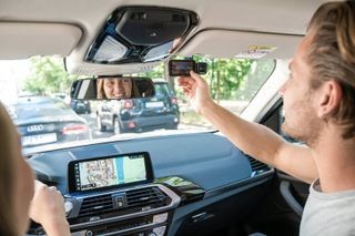 A man adjusting a Nextbase car dash camera in a car