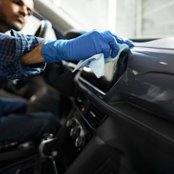 Man cleaning car interior with microfiber cloth