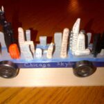 Close-up of a Chicago skyline pinewood derby car, emphasizing the detailed craftsmanship and fragile nature of the design, highlighting the need for pinewood derby care.