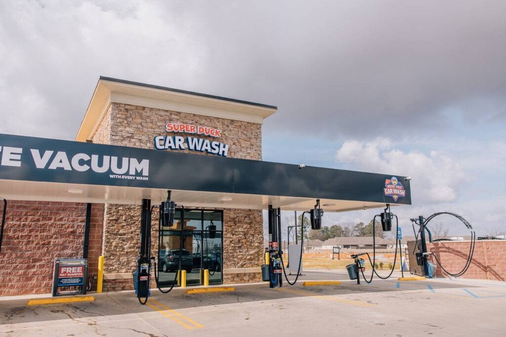 Exterior view of Super Duck Car Wash showing payment kiosks and entrance to the wash tunnel