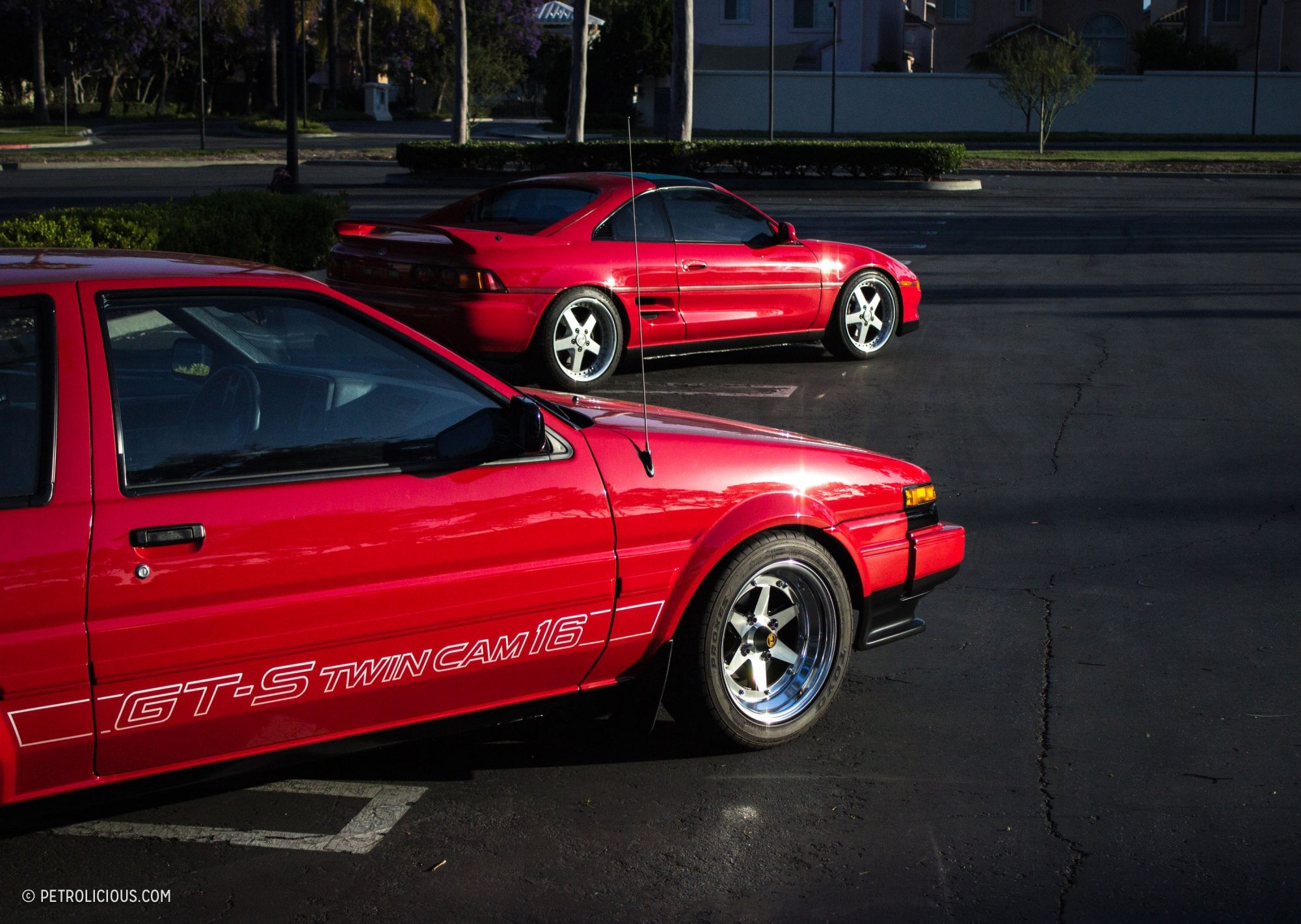 A pristine red Toyota AE86 GT-S coupe parked outdoors, showcasing its classic 80s design and SSR Longchamp XR-4 wheels.